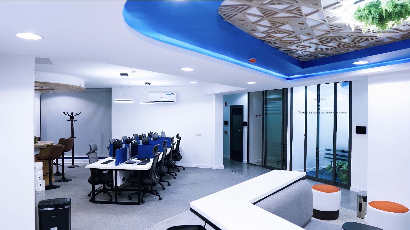 Roche Abuja workplace: reception area with open workstations and glazed meeting rooms beyond.