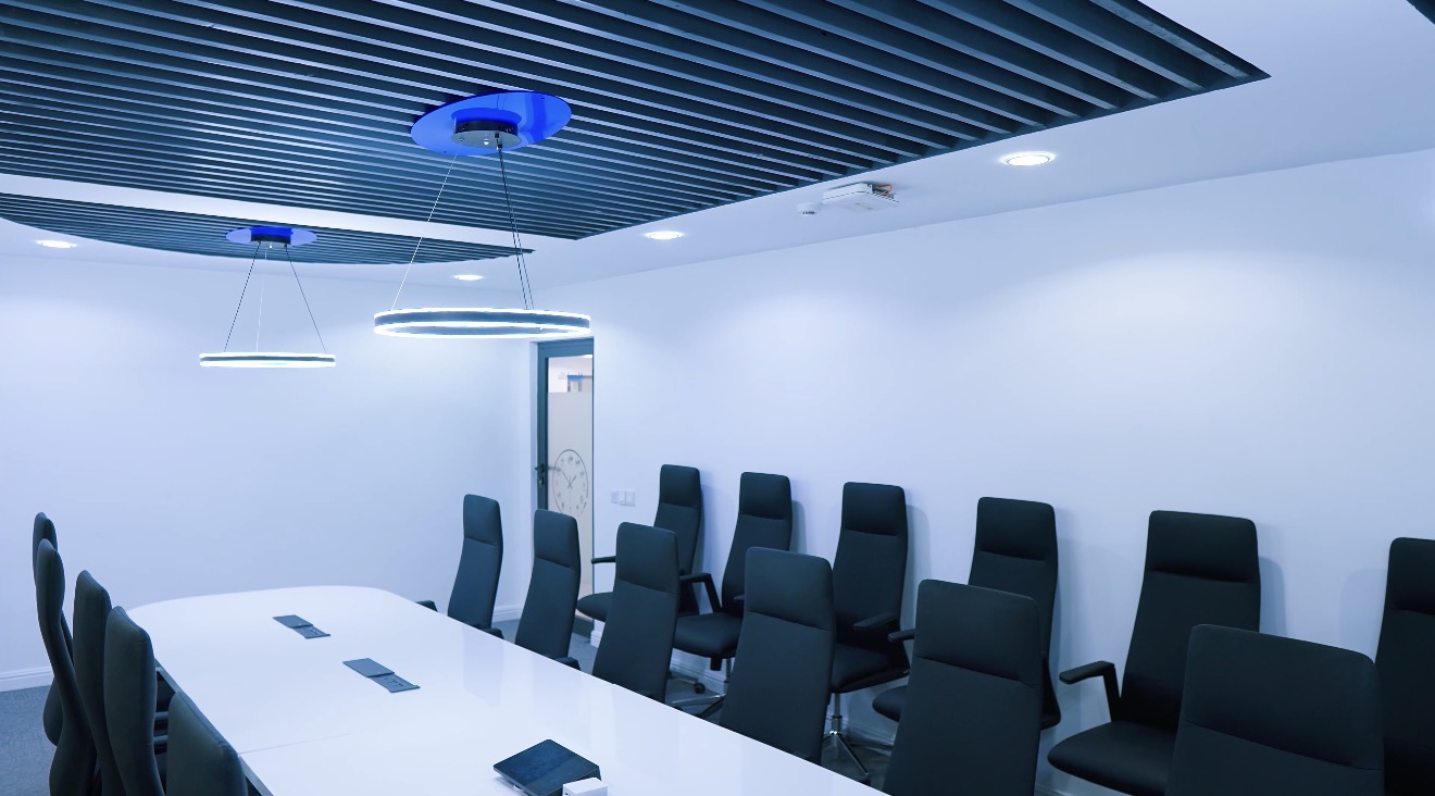 Roche Abuja boardroom with a long white table, black seating and linear ceiling detail.