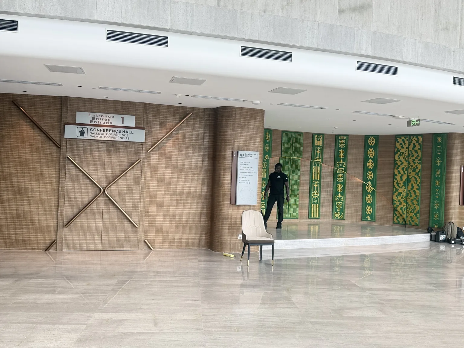 Conference hall entrance at the ECOWAS Commission headquarters, framed by green and gold decorative wall panels.